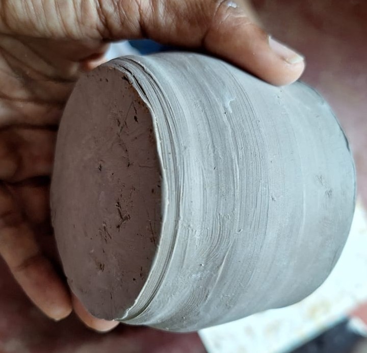 Detail of the trimmed foot ring base of a ceramic vessel in hand