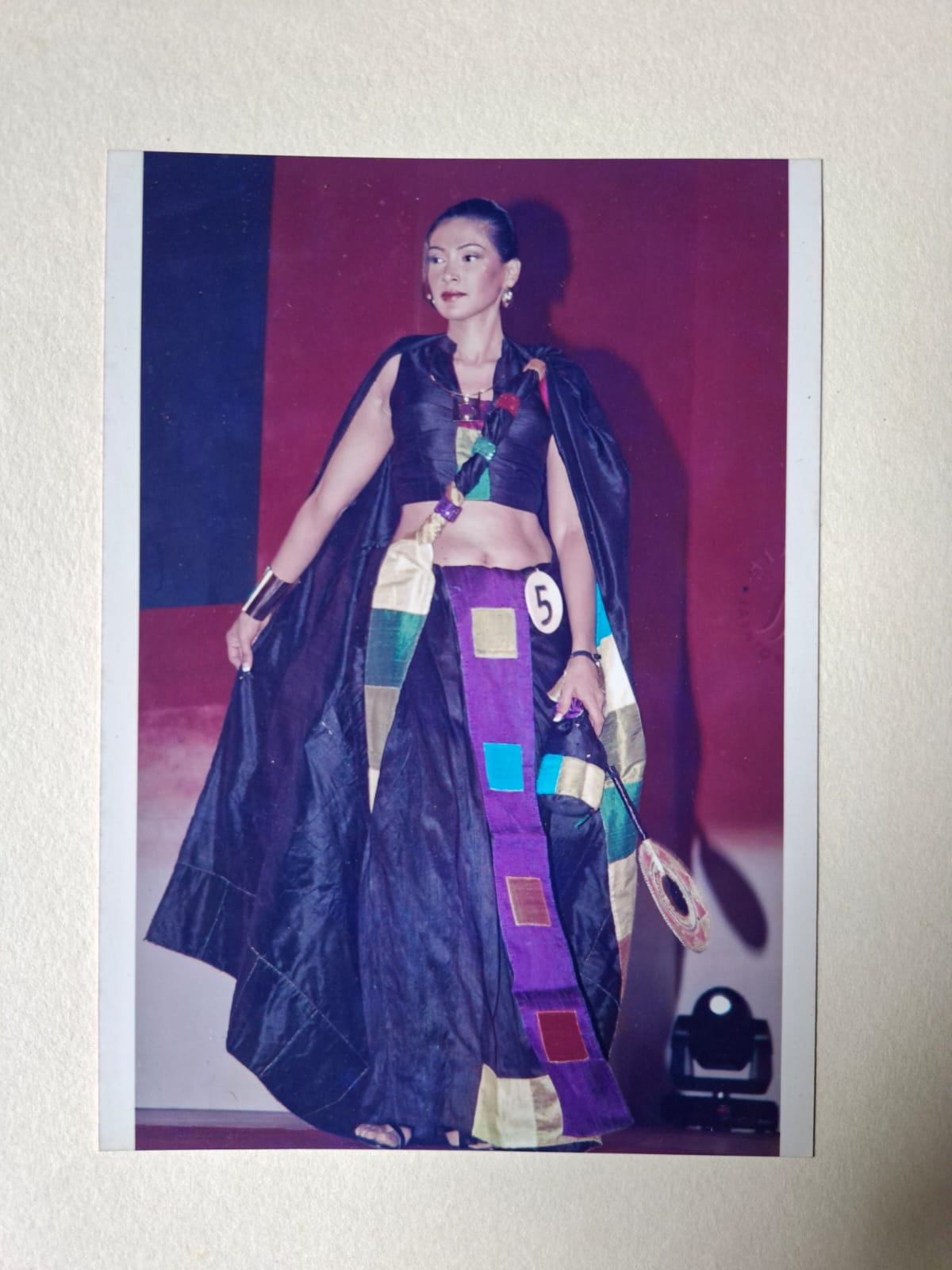 A model on the runway in a dark silk sari with multicoloured patchwork panels