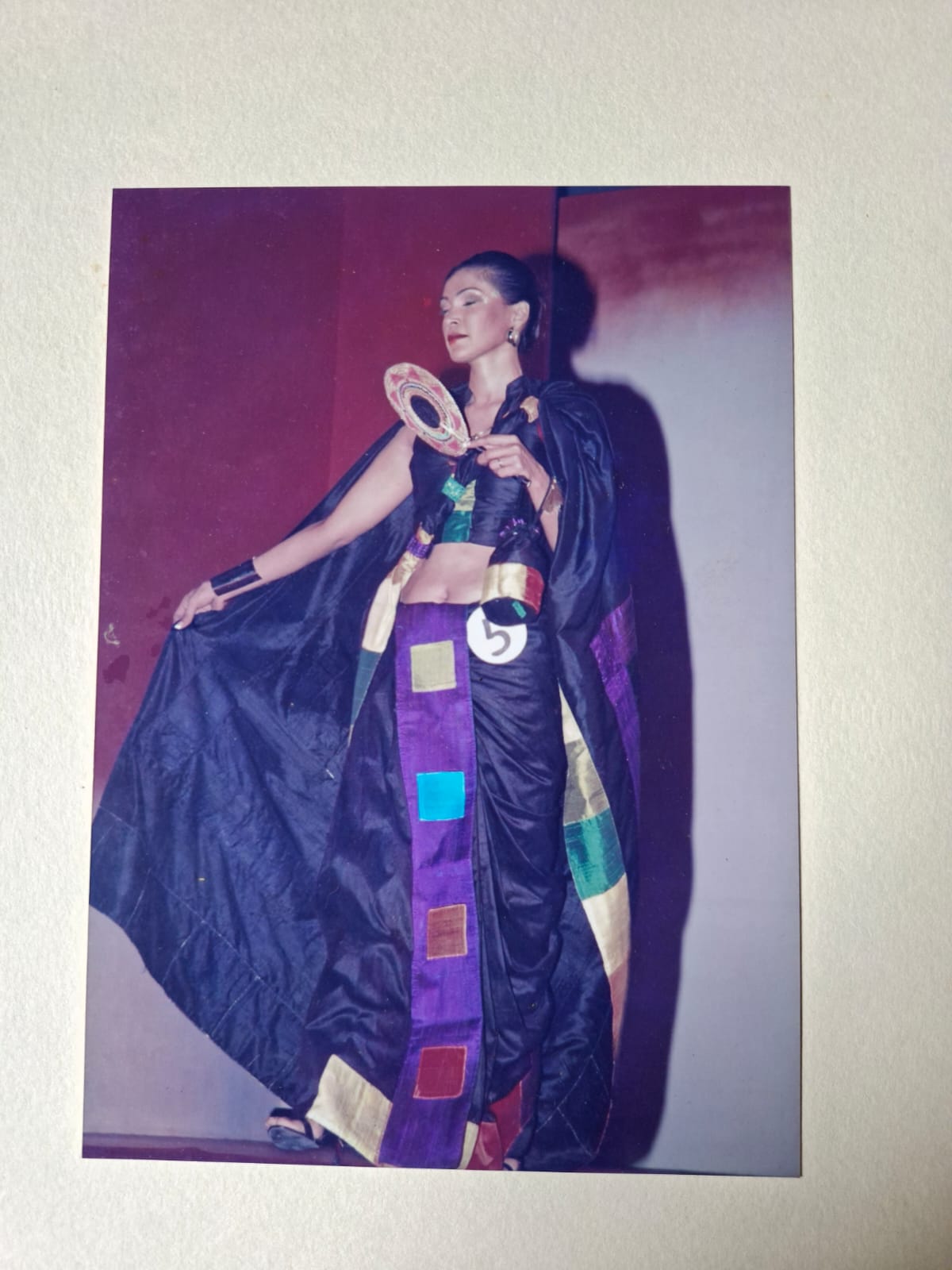 A model turning on stage, patchwork sari catching the light
