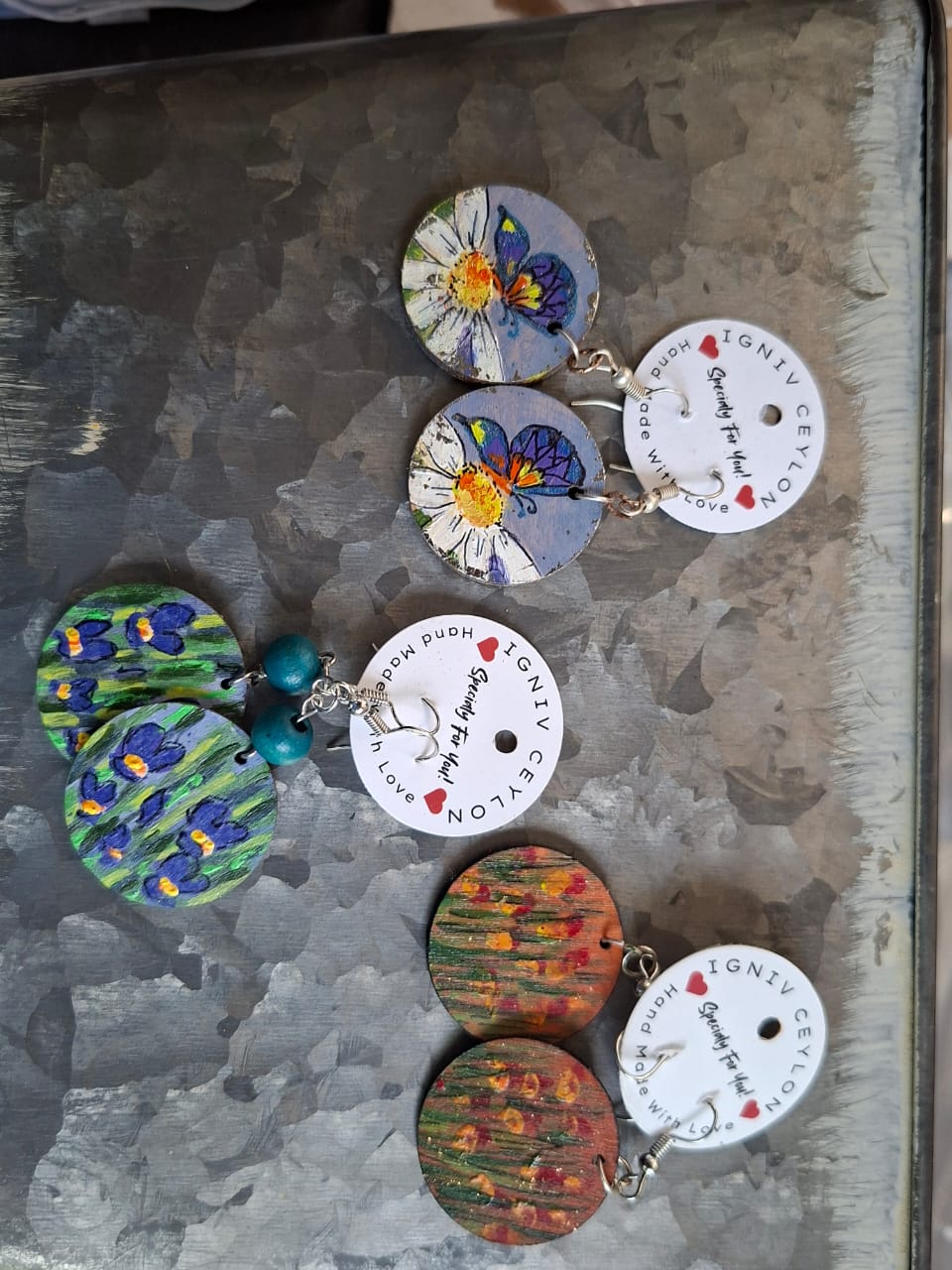 Hand painted wooden earrings showing butterflies, irises and poppies