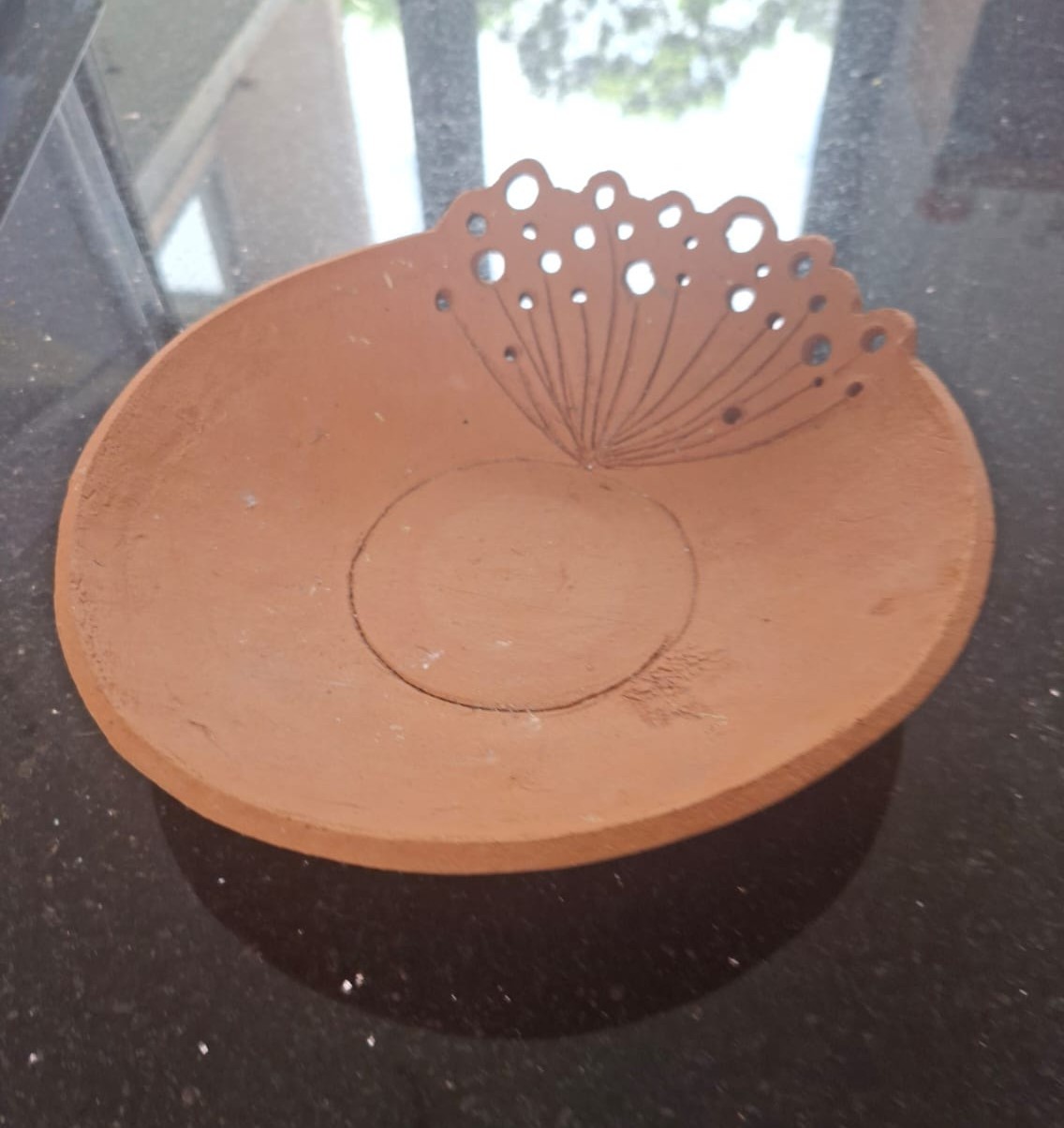 Handmade red clay pierced dandelion dish with intricate cutouts