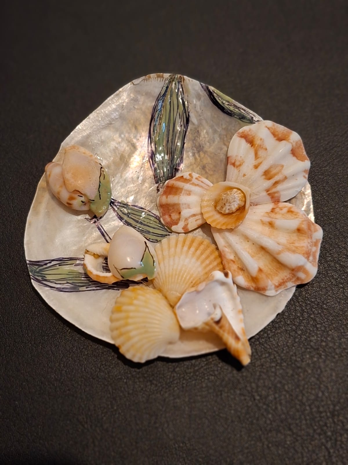 A mother of pearl dish painted with seagrass, set with scallop shell flowers