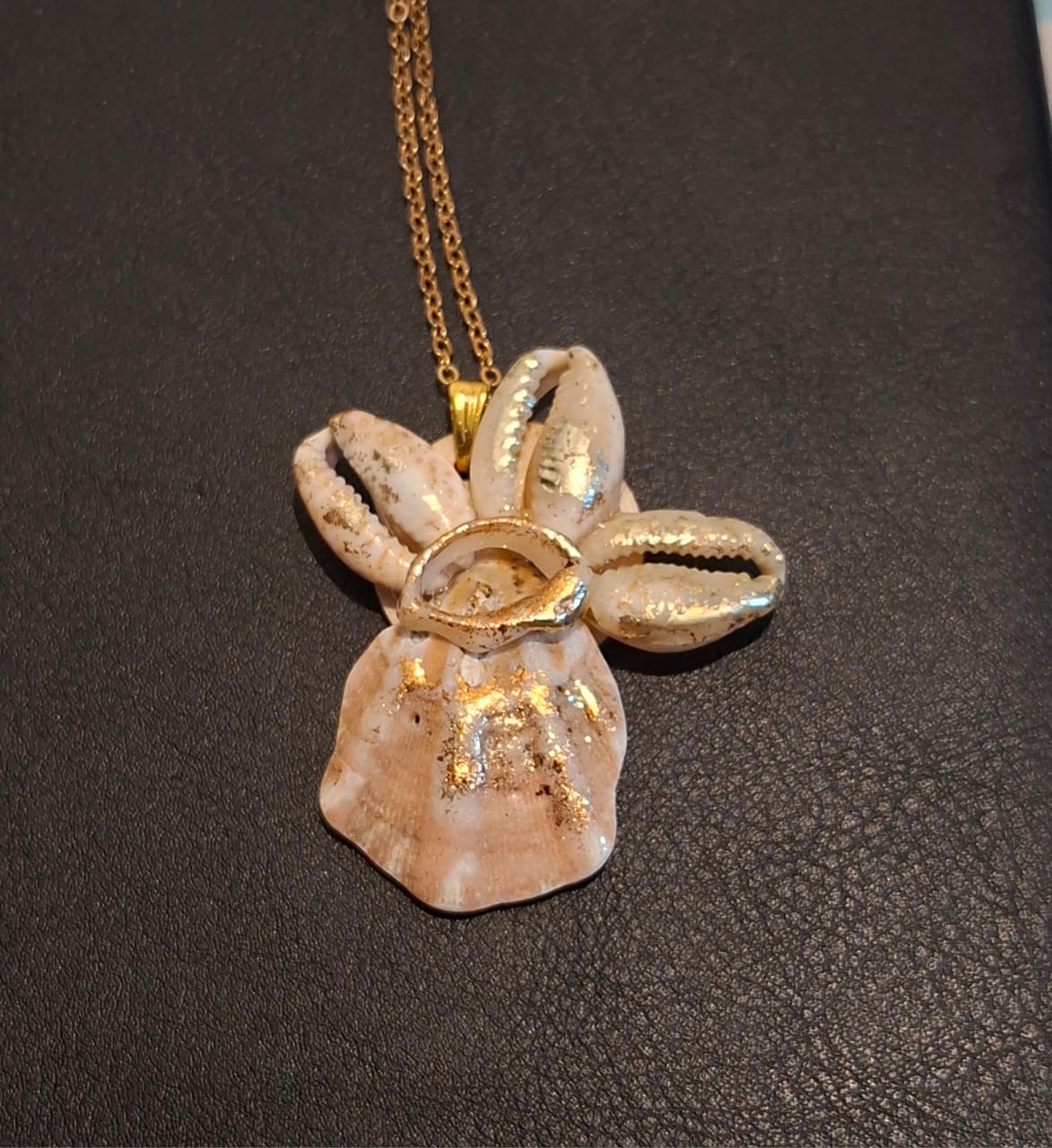 A pendant of gilded cowrie shells arranged as a star, on a gold chain